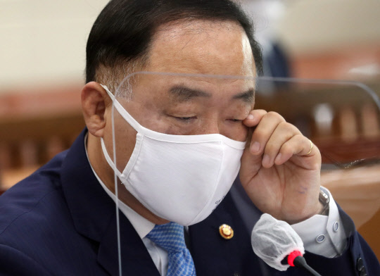 홍남기 부총리 겸 기획재정부 장관이 지난달 22일 서울 여의도 국회에서 열린 기획재정위원회의 국세청, 관세청, 조달청, 통계청 등에 대한 국정감사에 출석해 질의에 답변하며 눈을 만지고 있다. 연합뉴스